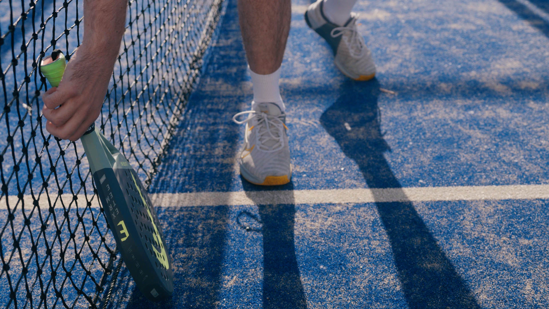 Padelspeler met racket bij het net