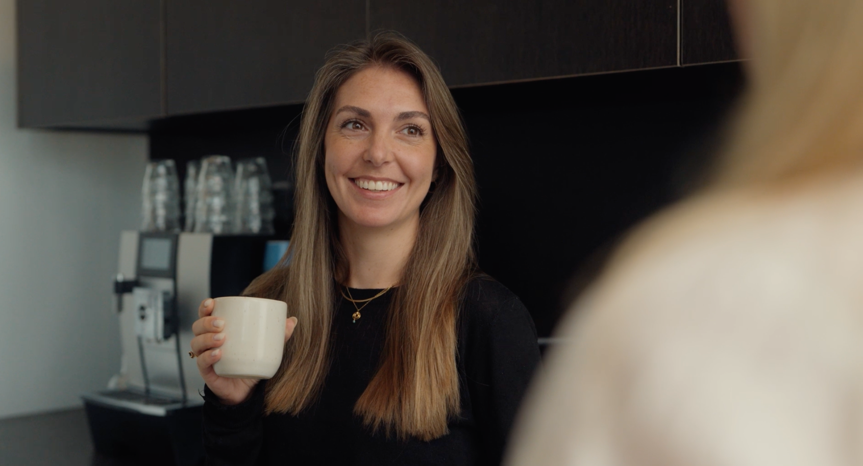 Collega van Addleshaw Goddard met een kop koffie in de pantry